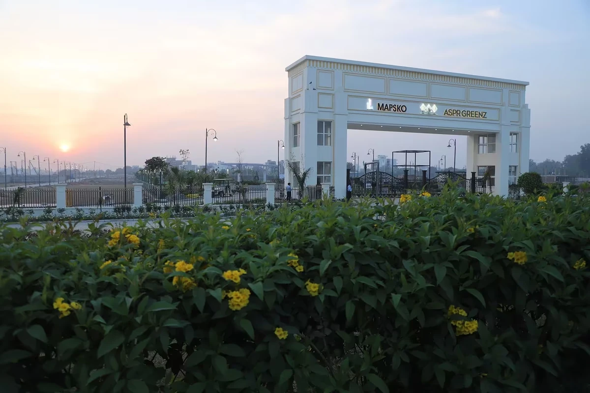Mapsko ASPR Greenz entrance gate with flowering green landscape at sunset – residential plots Sector 35 Sonipat