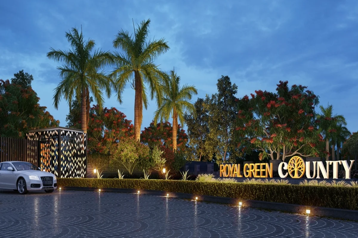 Royal Green County project signage with palm trees and ground lighting at the entrance in Kundli Sonipat