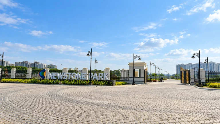 Newstone Park main entrance with landscaped greenery and a gated entry.